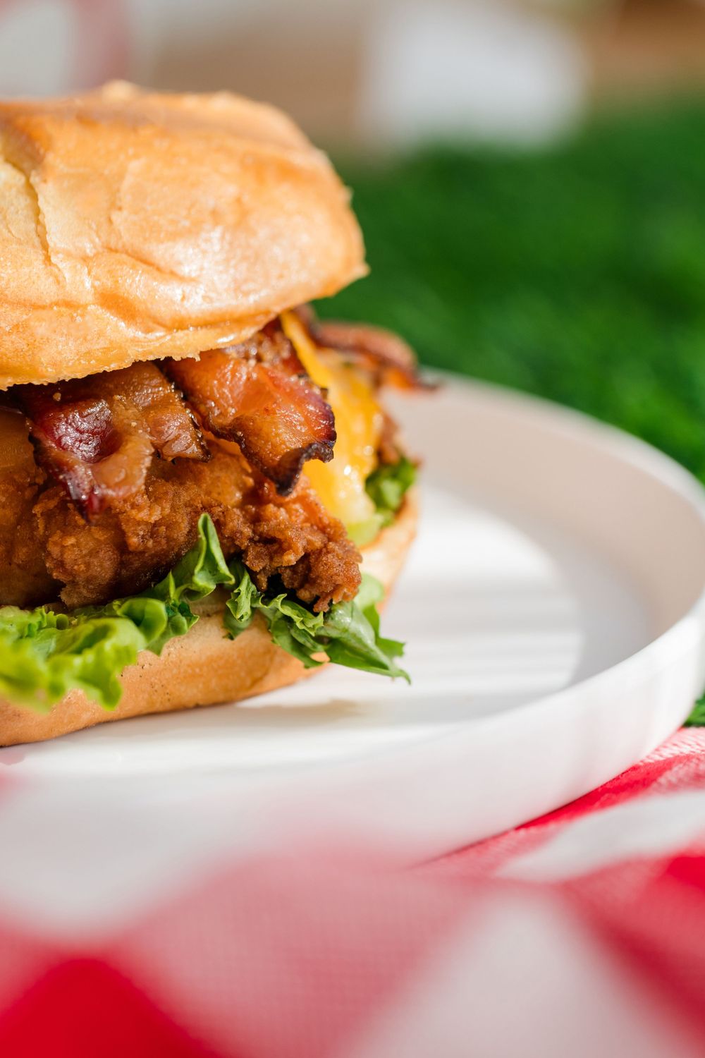 Close-up of crispy chicken sandwiches with lettuce on white plates.