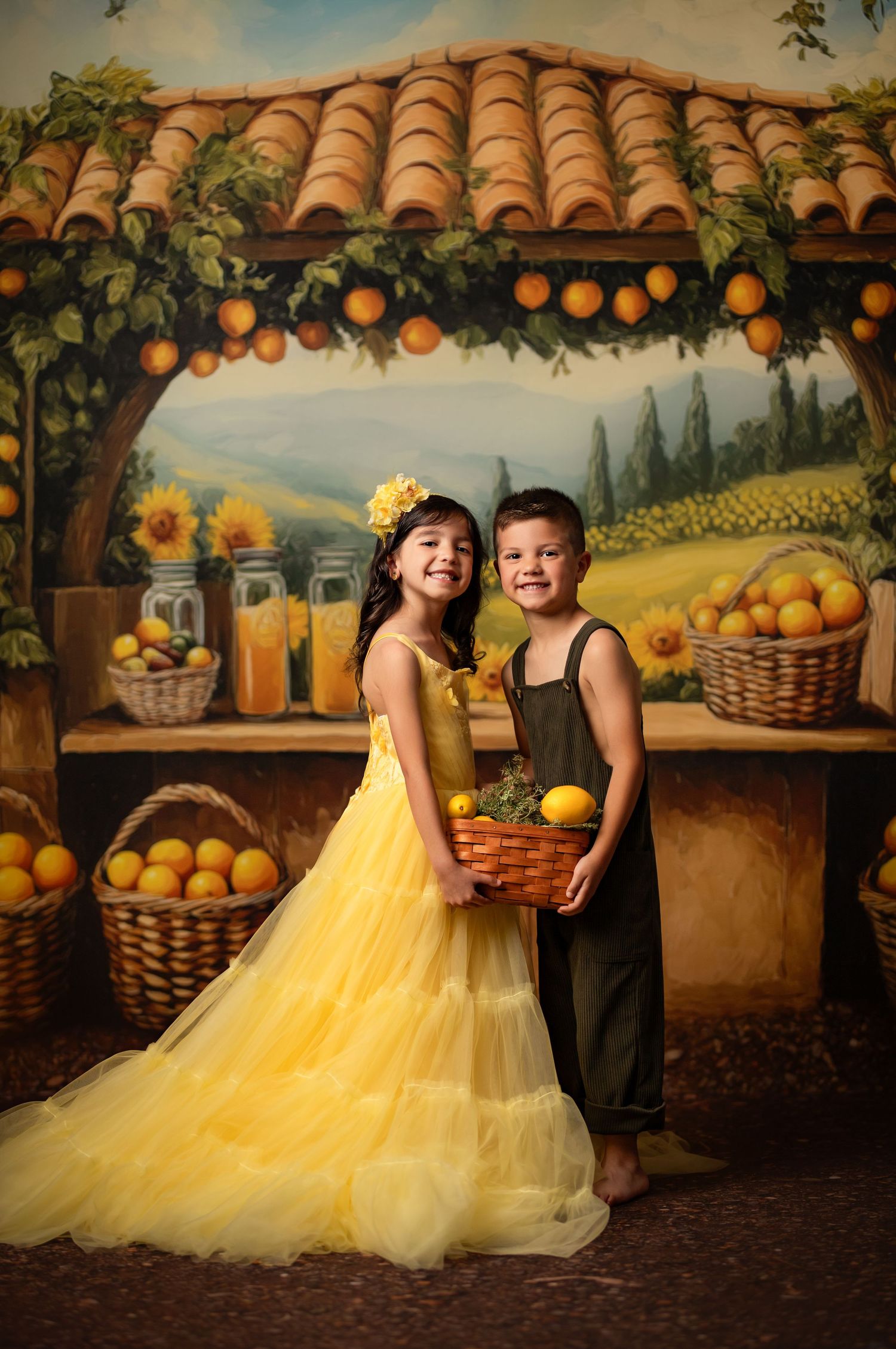 A charming rustic scene with citrus decor featuring yellow tulle dress and overalls against a Tuscan-inspired backdrop.