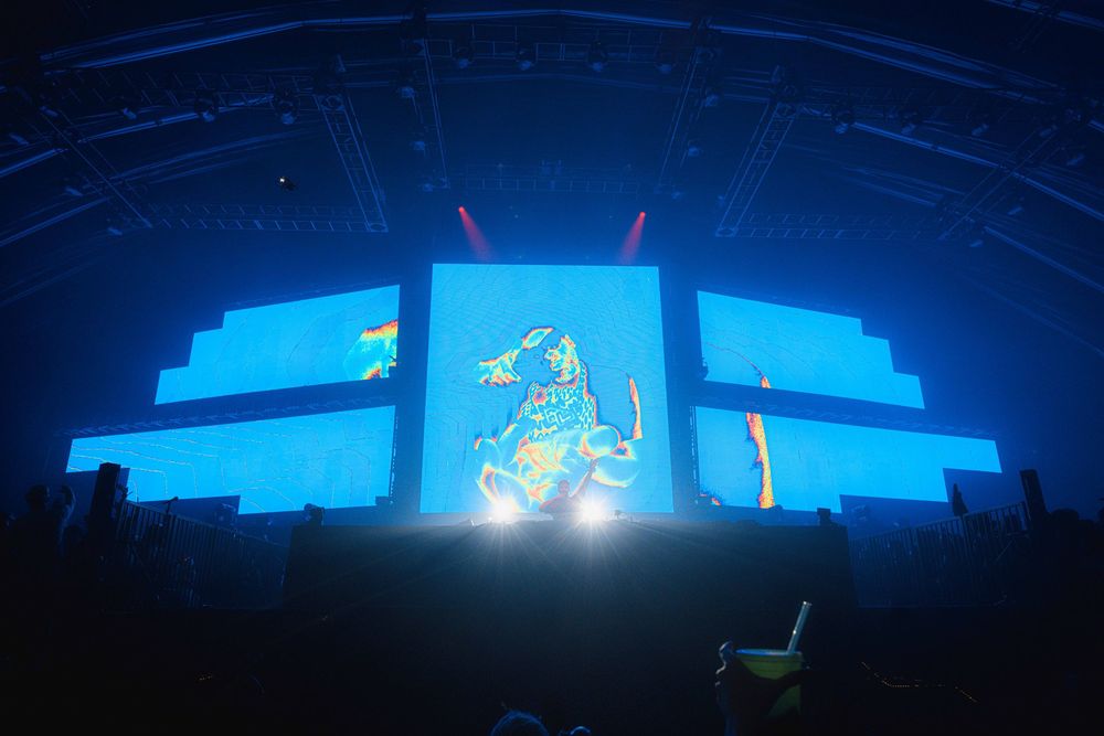 A series of blue neon-lit architectural structures shown in silhouette against a dark background.