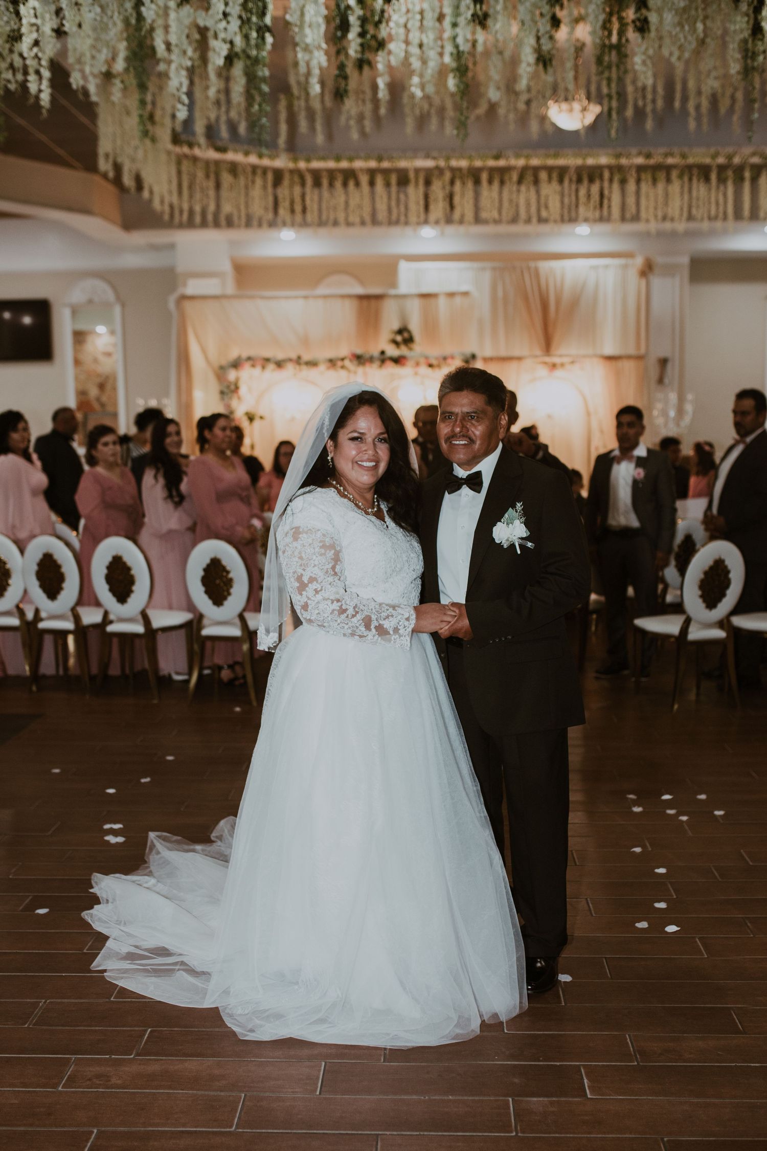 Bride and groom smiling together on wedding dance floor with floral decor.