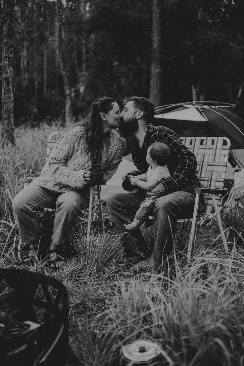Four vintage black and white photographs show people aiming rifles while lying in tall grass for target practice.