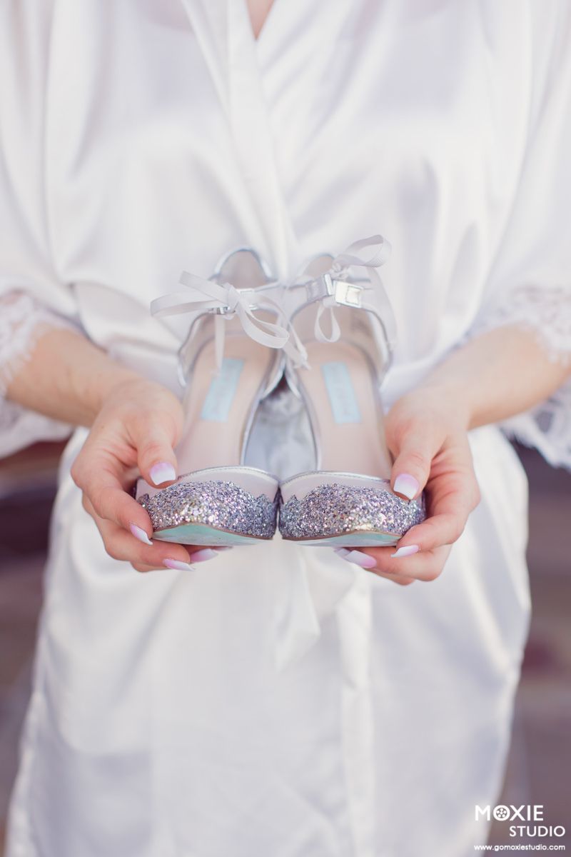 A series of hands holding sparkly silver wedding shoes arranged in a horizontal collage.