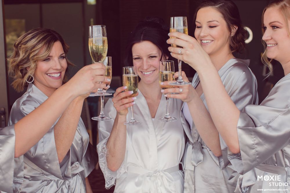 A group wearing gray and white clothing toasting with champagne glasses during a celebration.