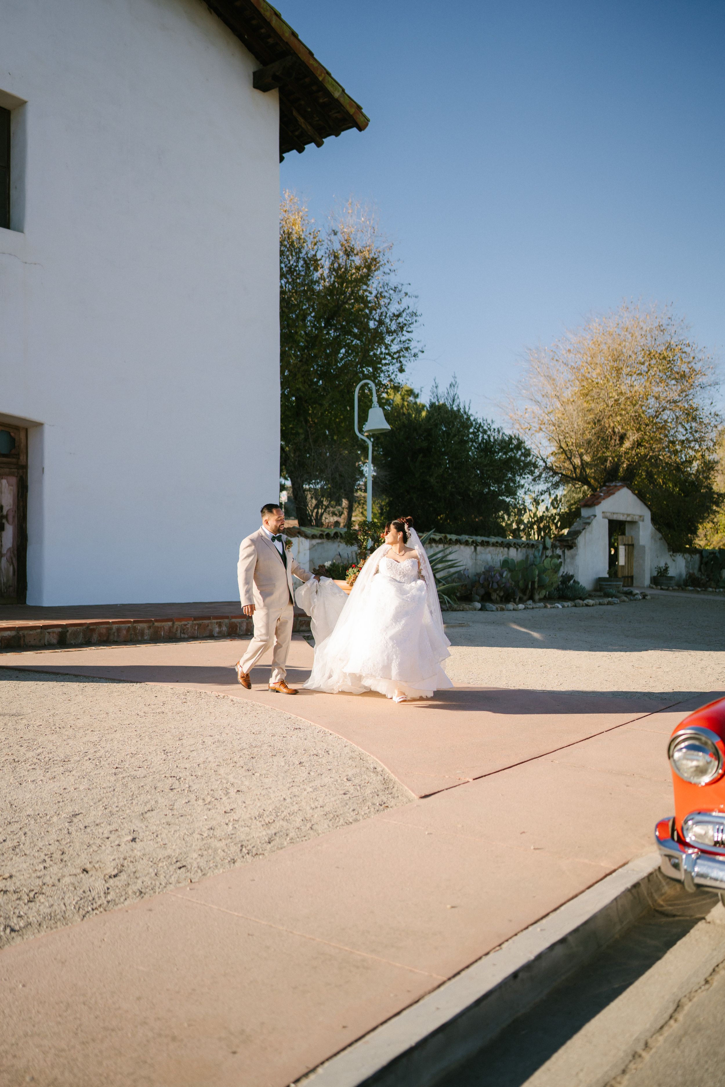 A sequence of four photos showing a bride's dress flowing in the wind outside a white building.