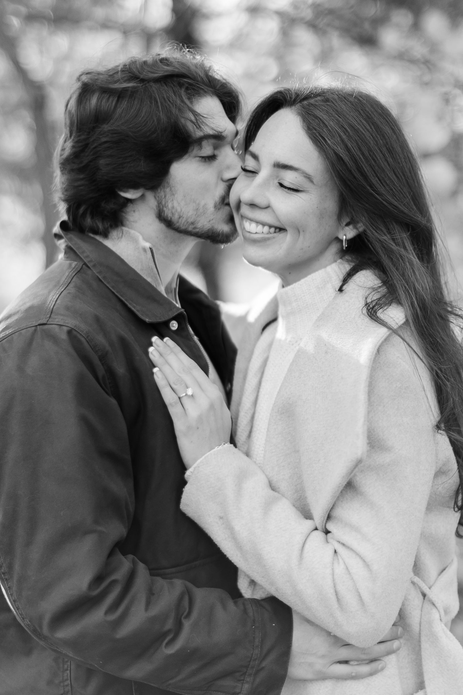 A romantic moment captured in black and white photography outdoors.