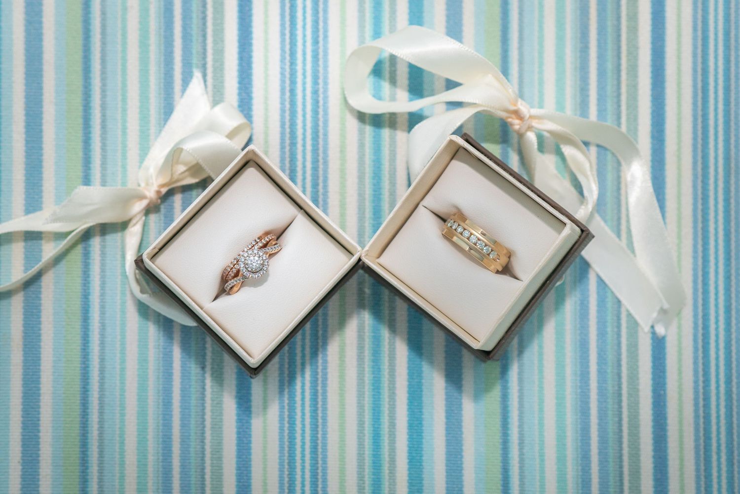 Elegant bridal shoes and accessories arranged on blue striped background.