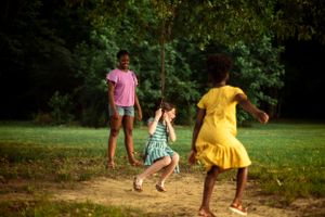 Memphis Family Photographer portrait of siblings playing at Shelby Farms during Golden Hour.