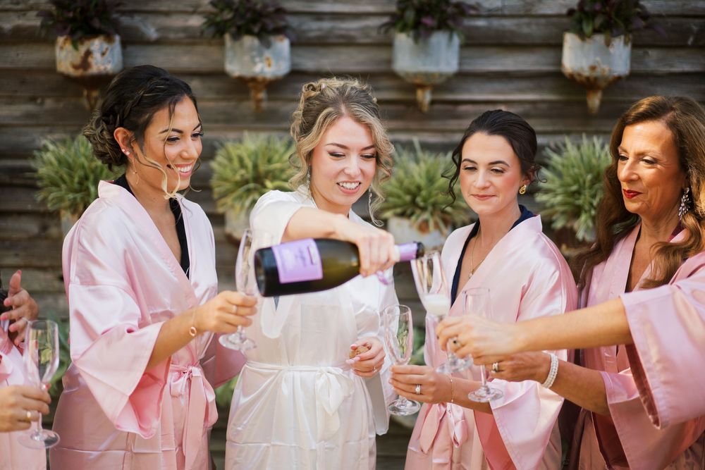 A celebratory moment with champagne being poured into glasses during pre-wedding preparations.