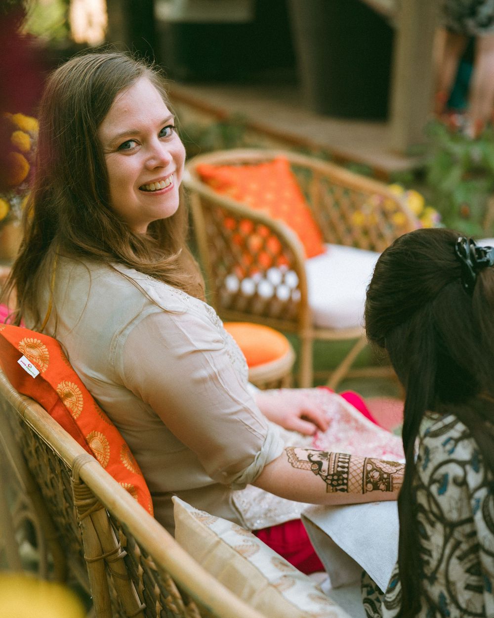Guests relaxing in wicker chairs at an outdoor garden party.
