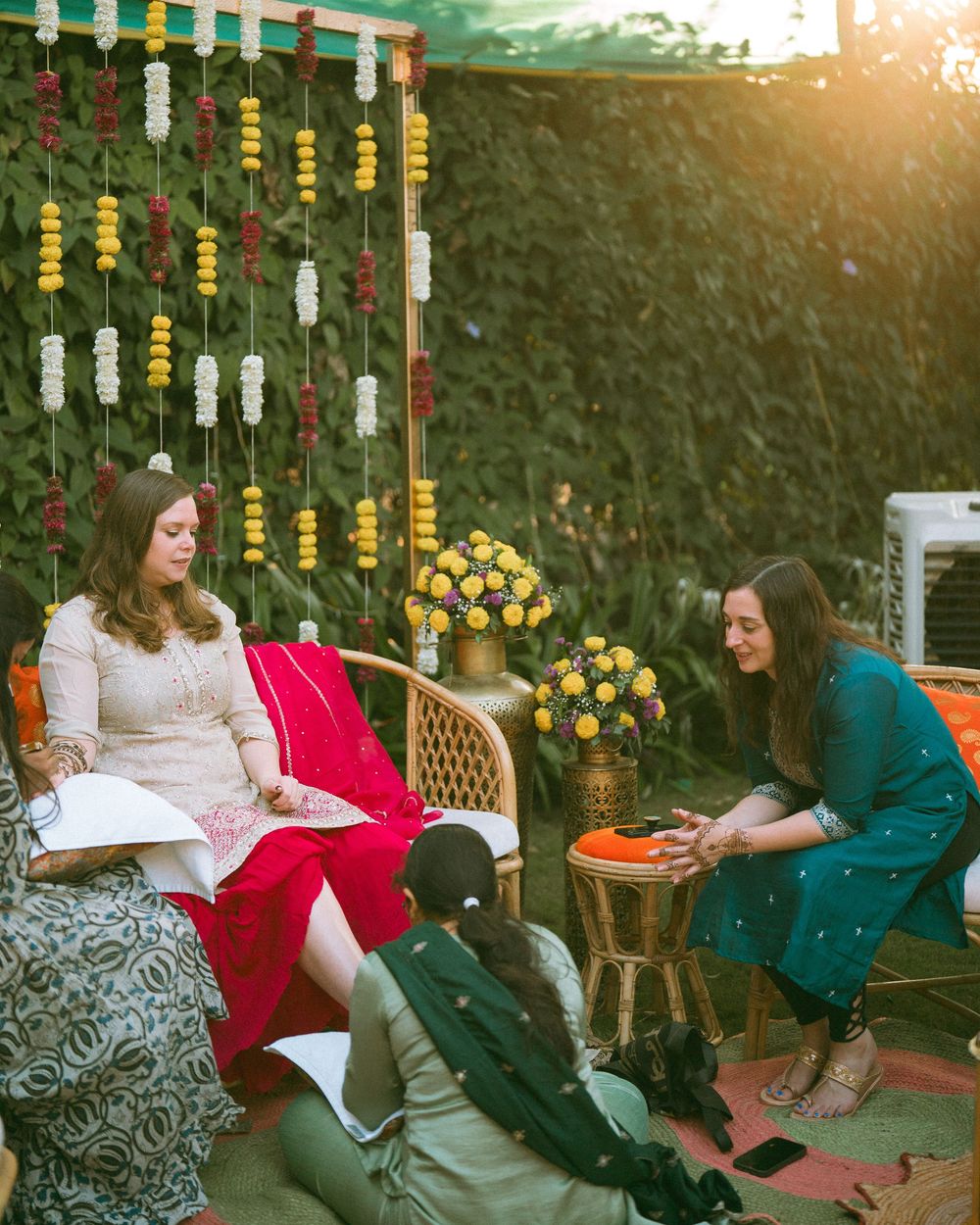 Outdoor seating area decorated with hanging yellow and white garlands at sunset.