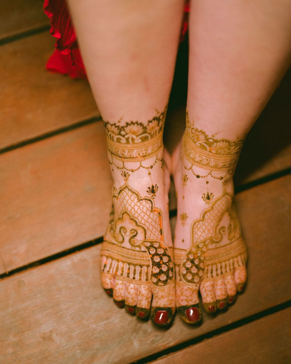 Intricate henna patterns adorning feet with traditional Indian anklet decorations.