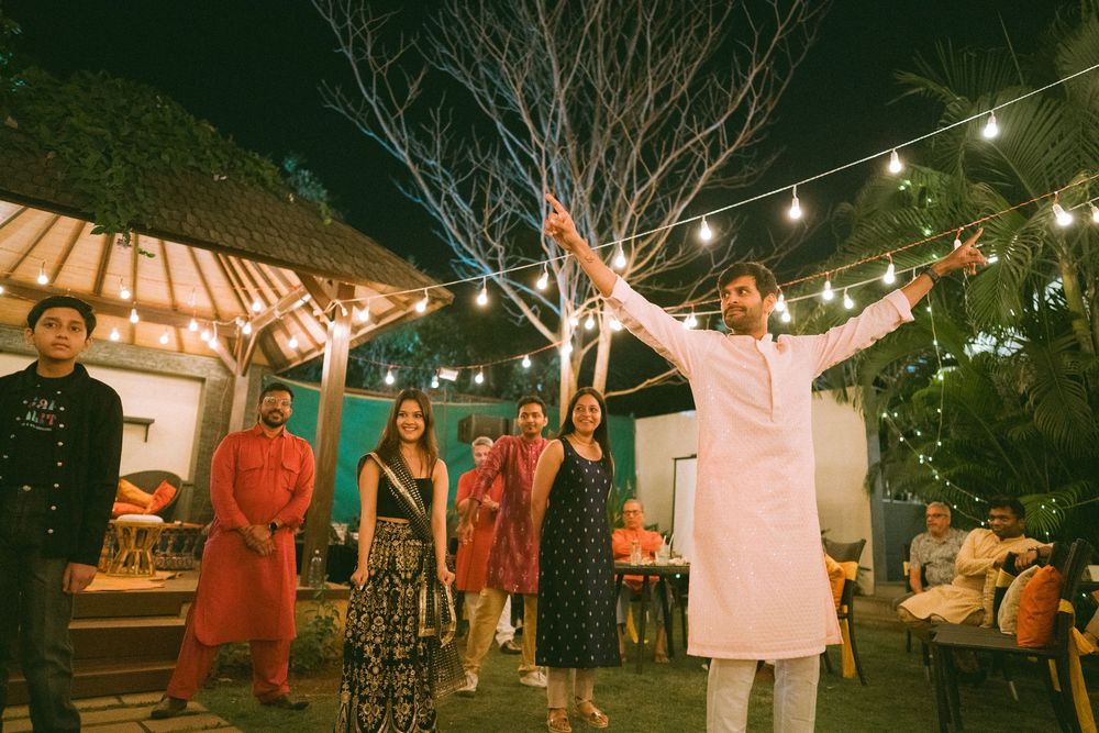 Outdoor party scene with string lights and people celebrating under covered pavilion.