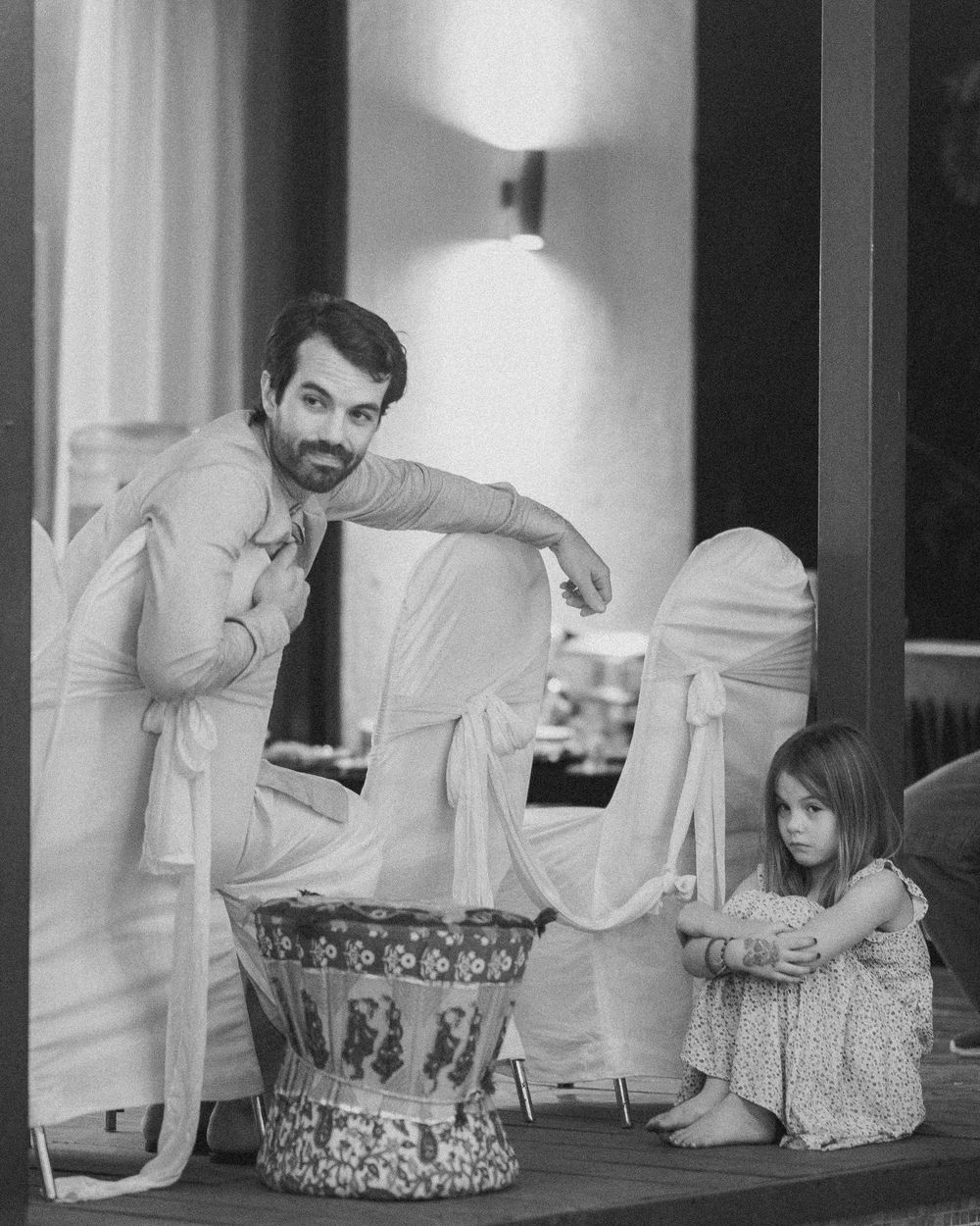 Black and white candid shots of people interacting at an indoor celebration.