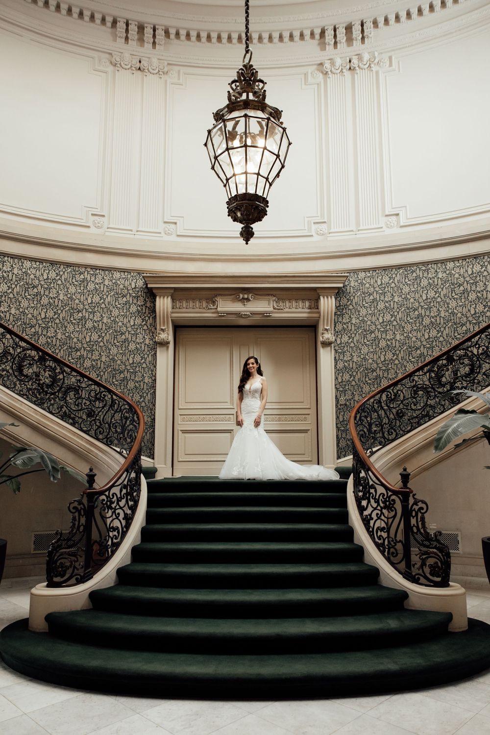 A sequence of elegant staircase photos in a grand estate featuring ornate iron railings and dramatic lighting.