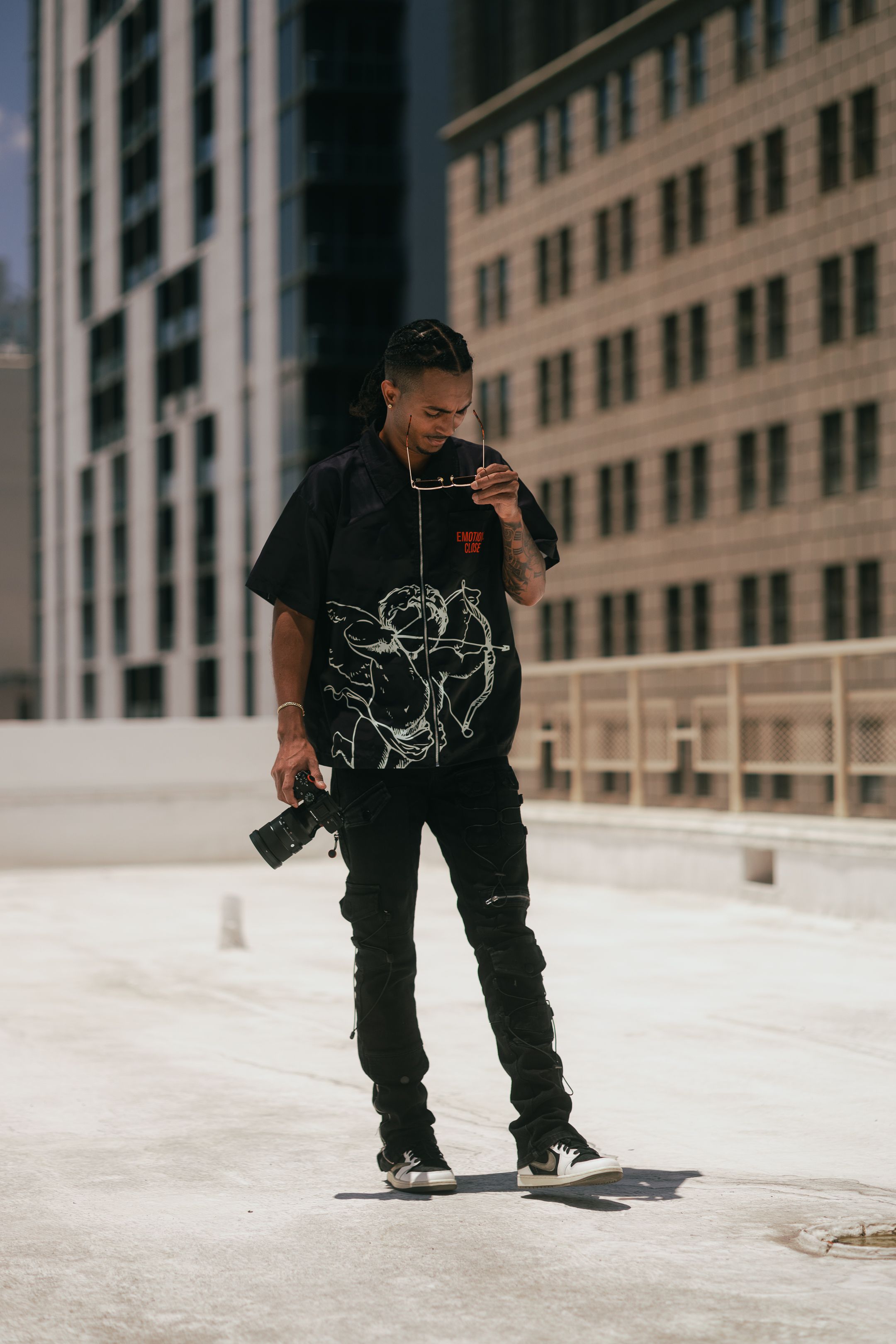 Streetwear model posing in all-black outfit on Miami rooftop, urban editorial inspired by Supreme and Gucci, styled for Pinterest boards.