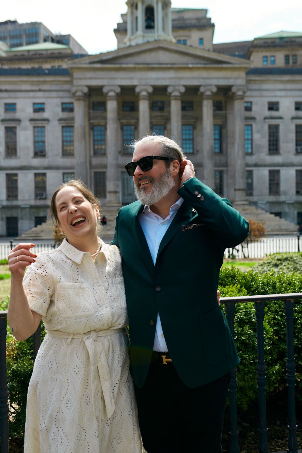 A couple shares joyful moments in front of a grand historic building with classical architecture. Wedding photography