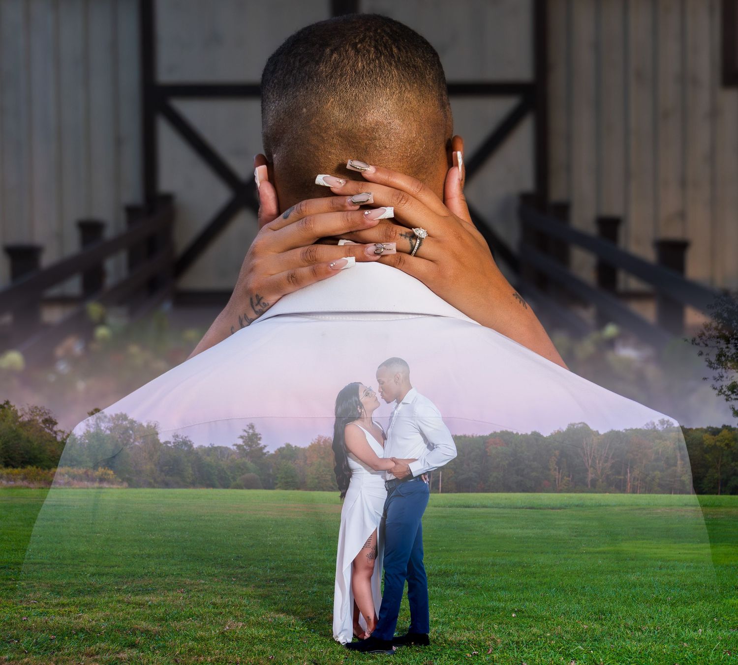 A couple in white clothing embraces while standing on a misty green field at sunset.