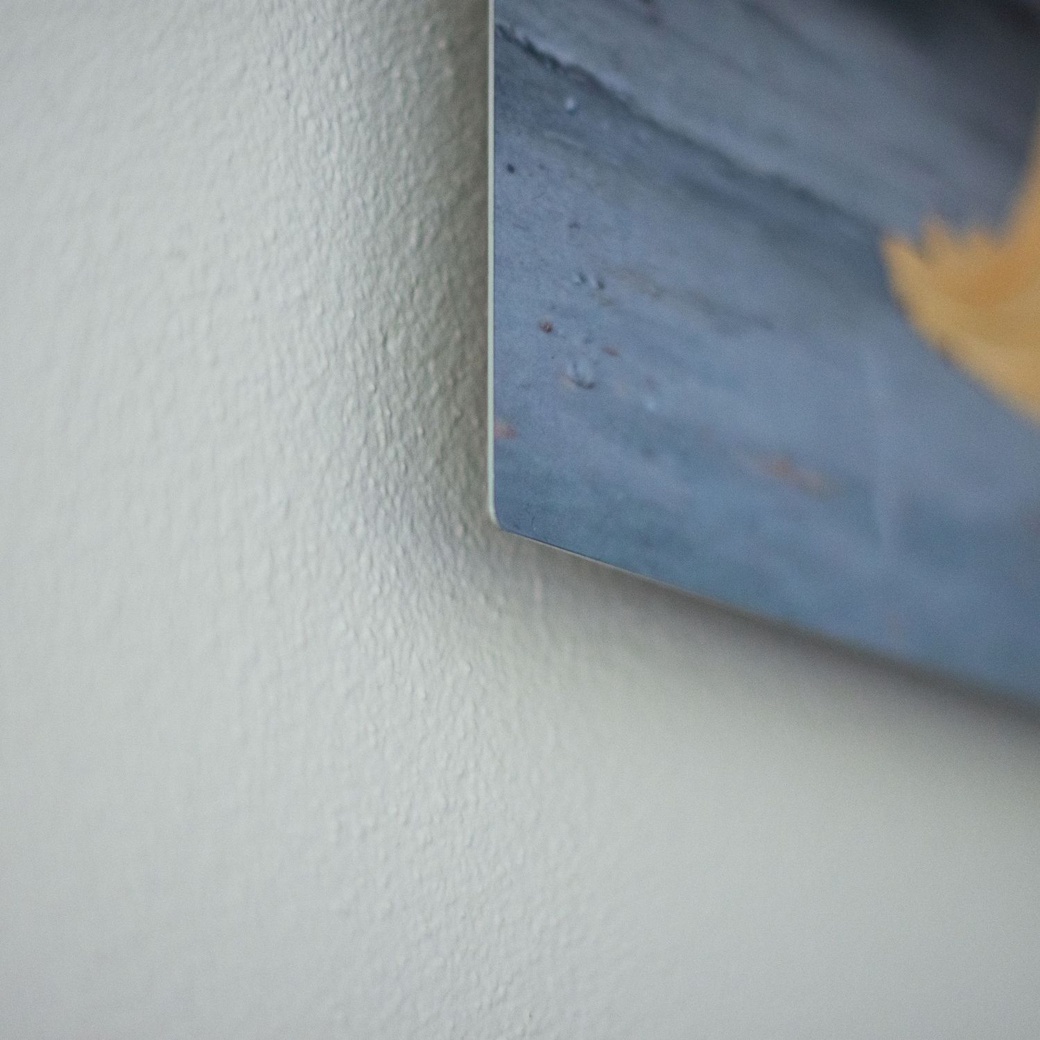 Close-up detail of mounted photographic prints on textured wall.