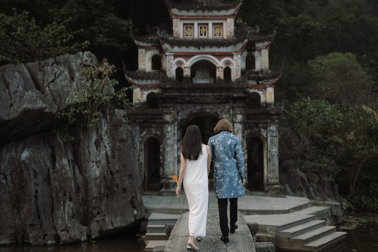 Several people explore a mystical stone archway surrounded by lush greenery at an ancient temple site.