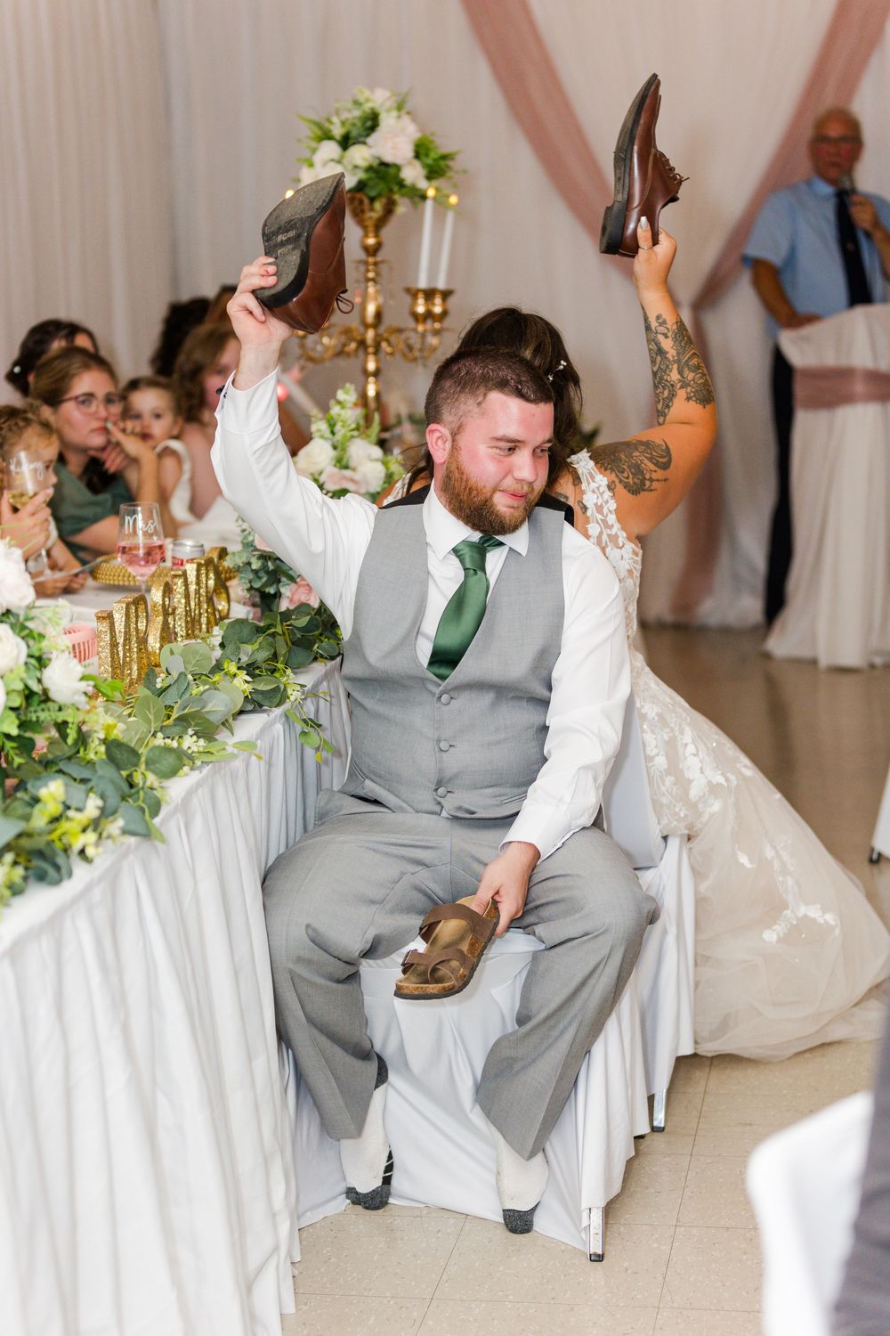 A sequence of wedding guests dancing and celebrating during a reception with white draped backdrop and floral decorations.