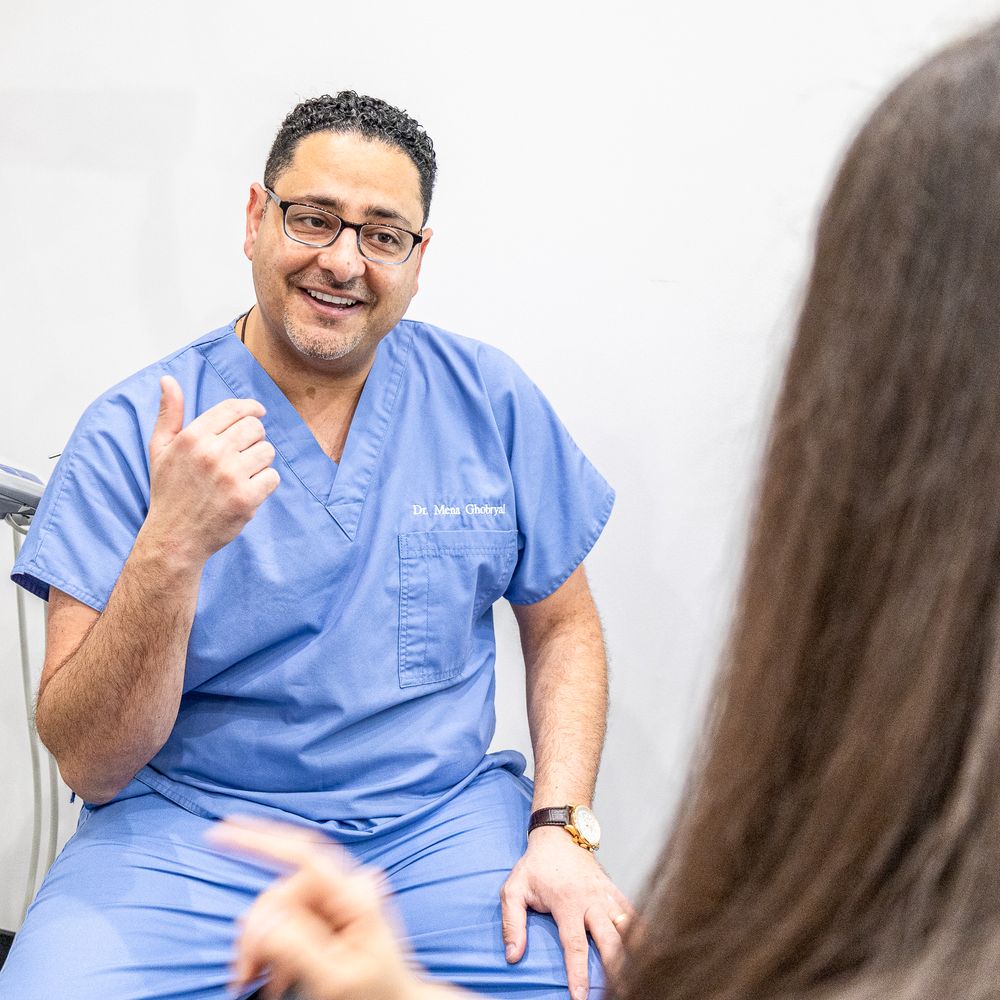 Healthcare provider in blue scrubs gestures while having animated discussion.