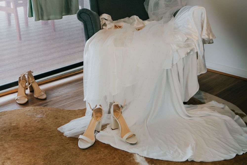 A series of elegant white bridal gown detail shots showing flowing fabric and delicate shoes arranged side by side.