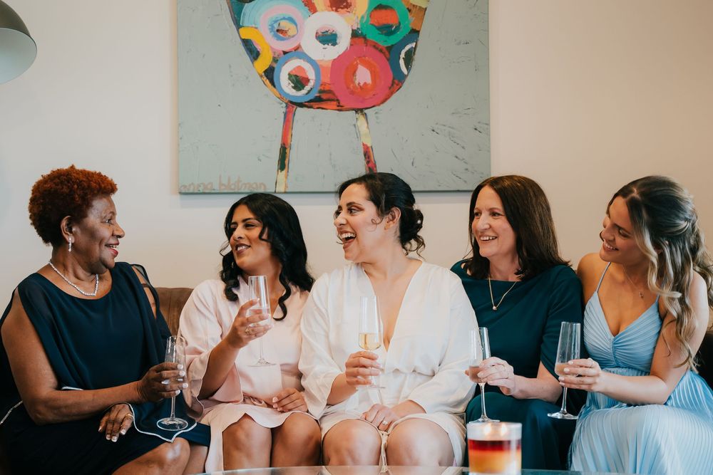 Diverse group of friends having drinks and engaging in animated conversation at a gathering.