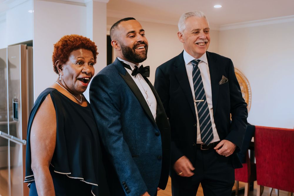 A group of formally dressed guests share laughs and conversations during an elegant event.