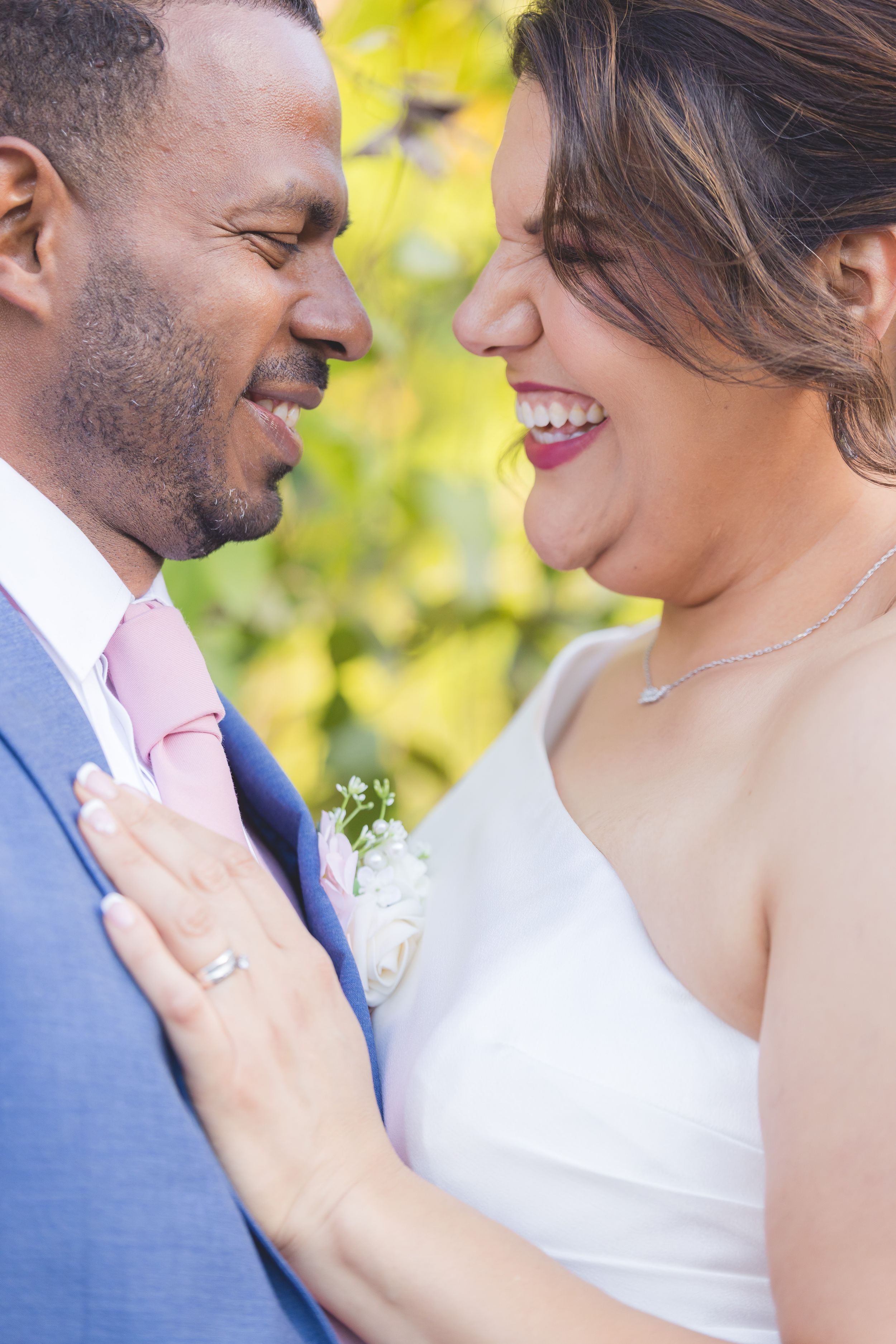 A romantic moment captured between a couple in wedding attire with soft yellow bokeh lighting in the background.
