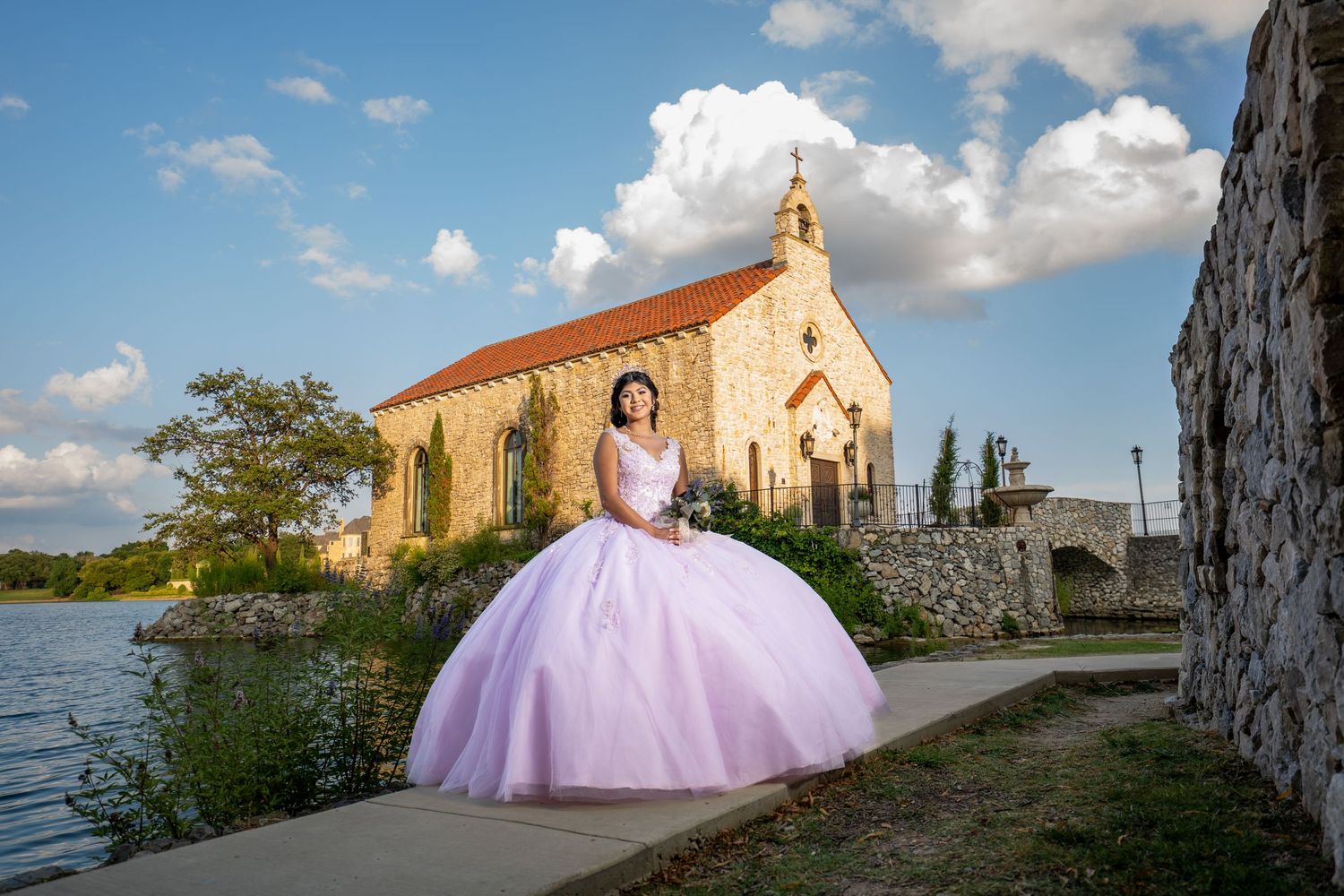 A scenic series of quince photos taken at a waterfront stone church location with soft pink tulle dress details.