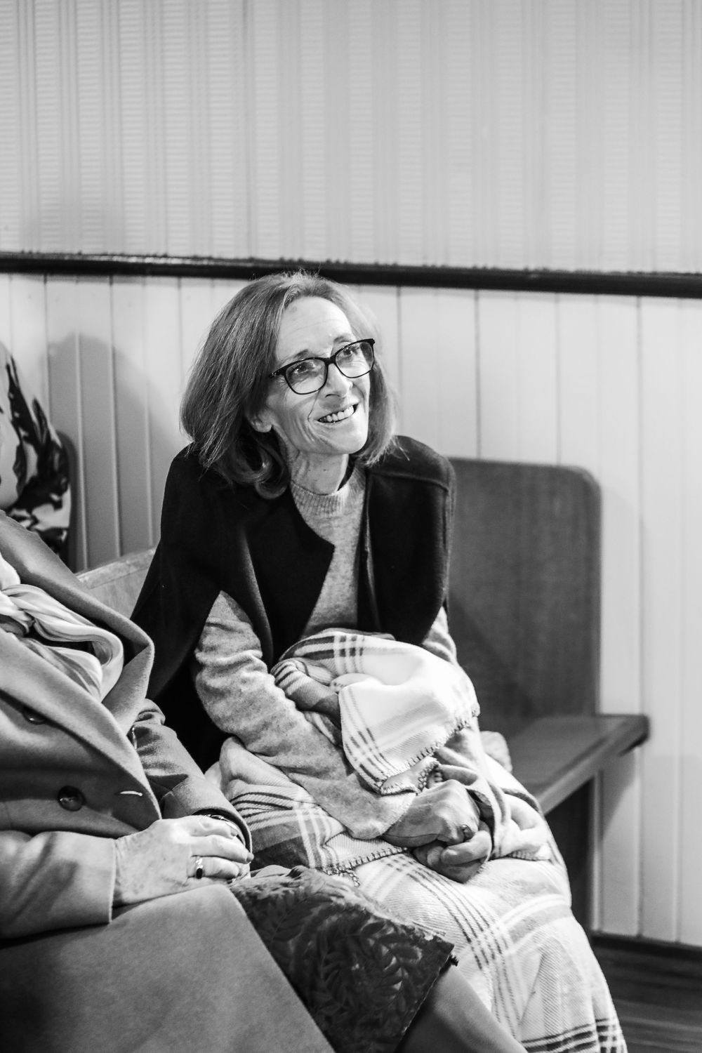 Black and white candid photos of a person relaxing and laughing on a couch.