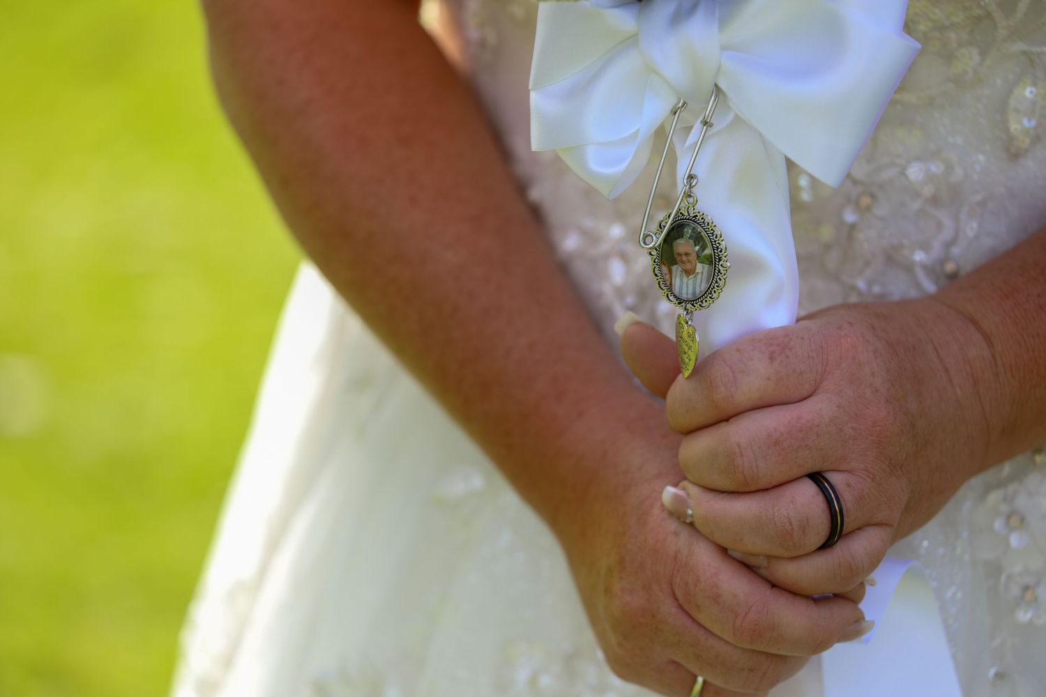 Close-up of hands holding during an outdoor wedding ceremony.
