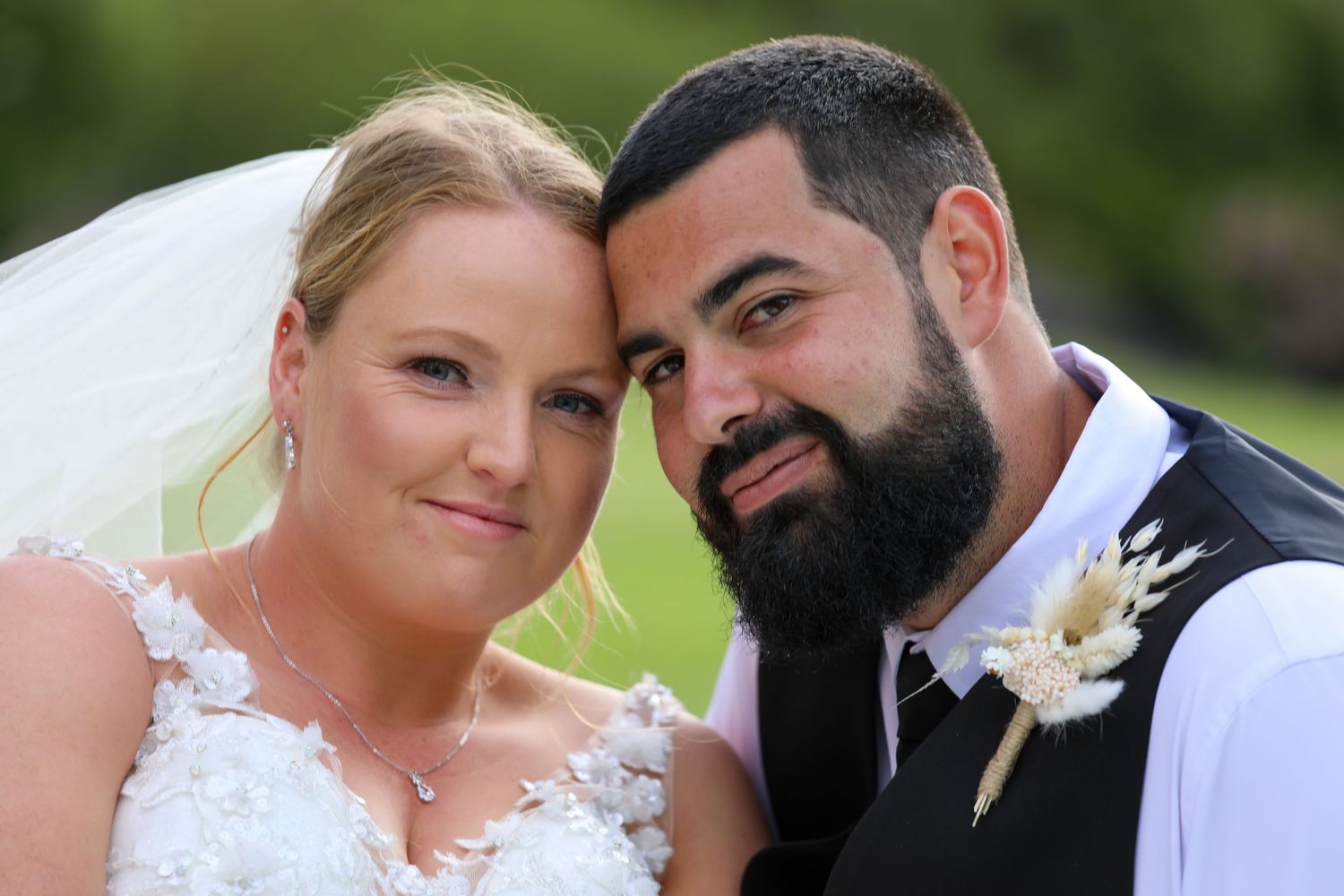 Tender moment captured between newlyweds during their outdoor spring wedding ceremony.