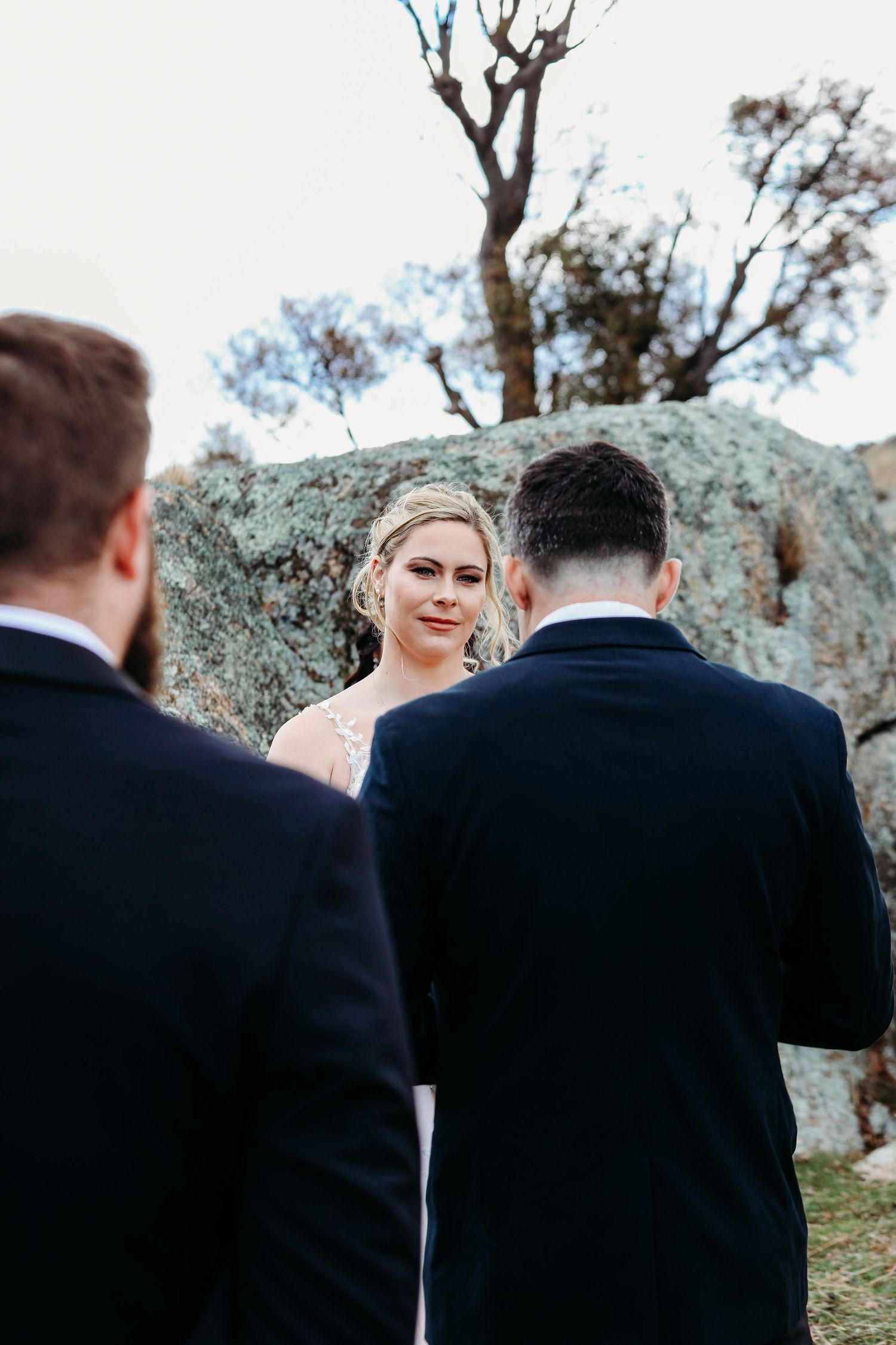 A couple shares an emotional moment during their outdoor mountain wedding ceremony.