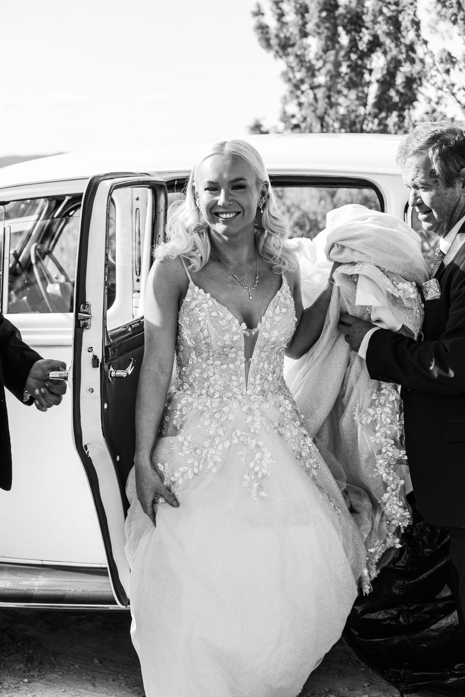 Sequence showing a bride in a beaded gown getting into a classic white wedding car.