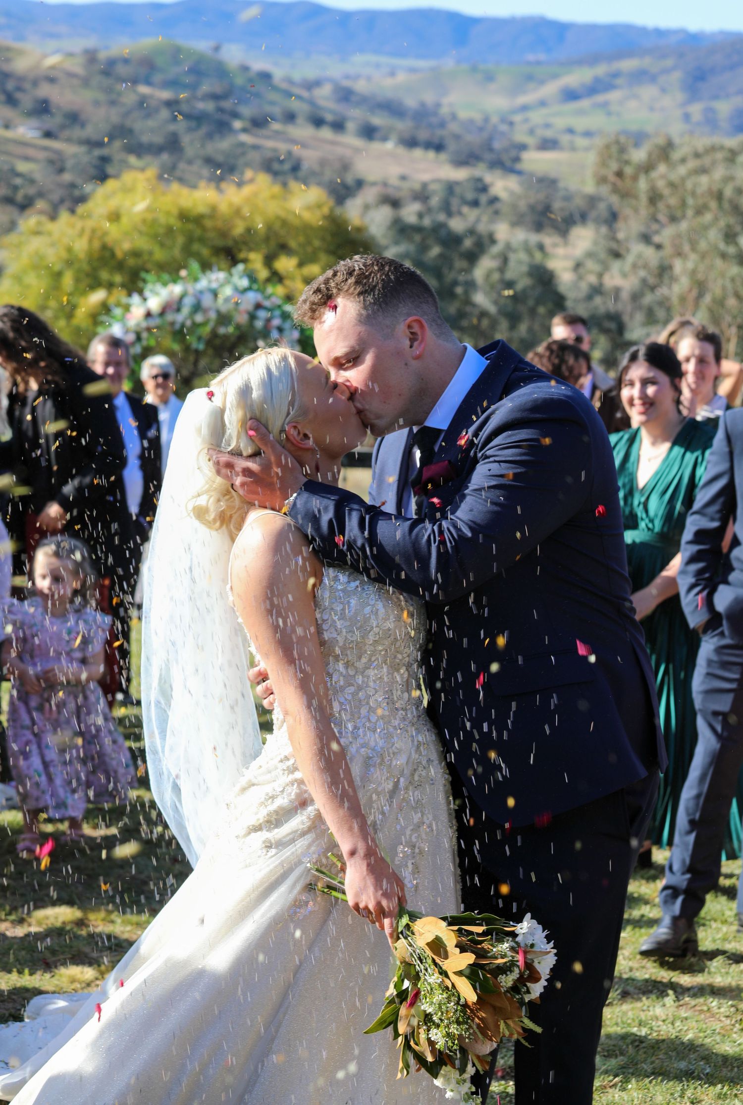 Wedding celebration in mountain landscape with confetti toss.