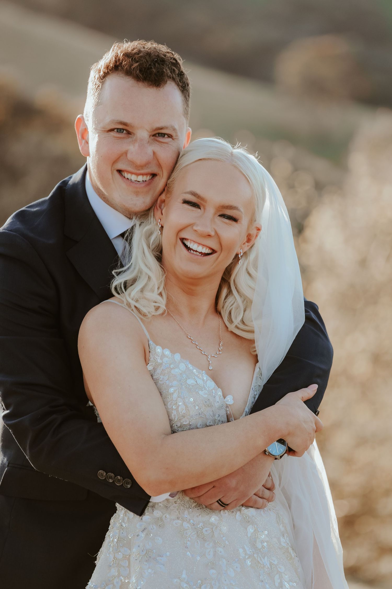 Romantic wedding portrait against mountain backdrop during golden hour.