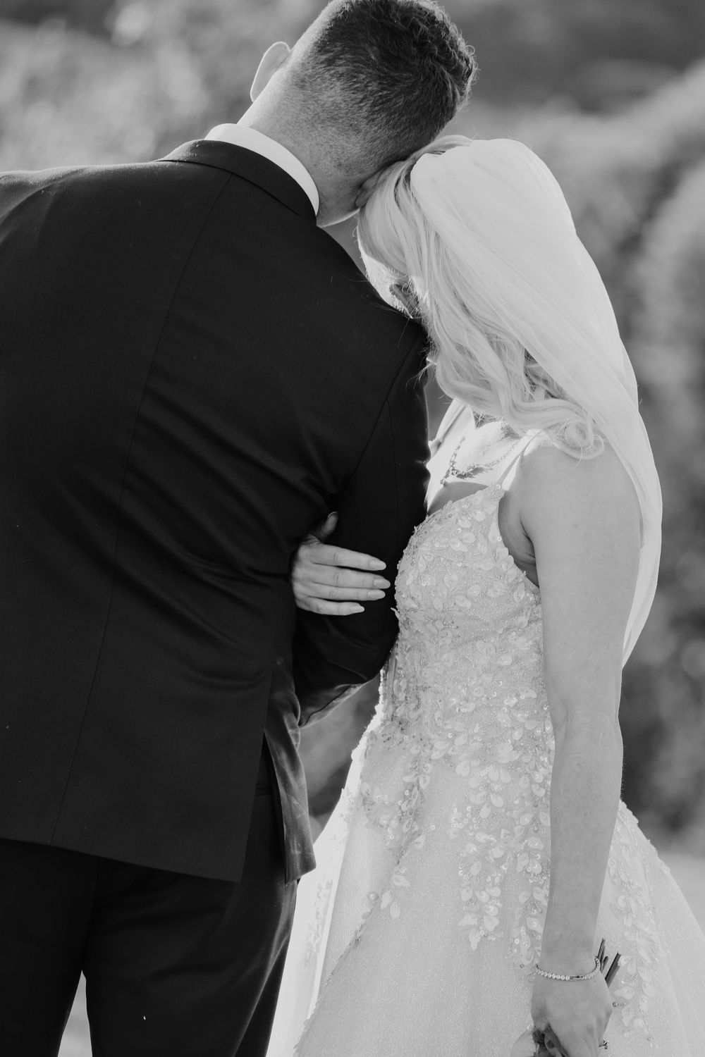 Intimate black and white wedding portrait showing tender embrace.