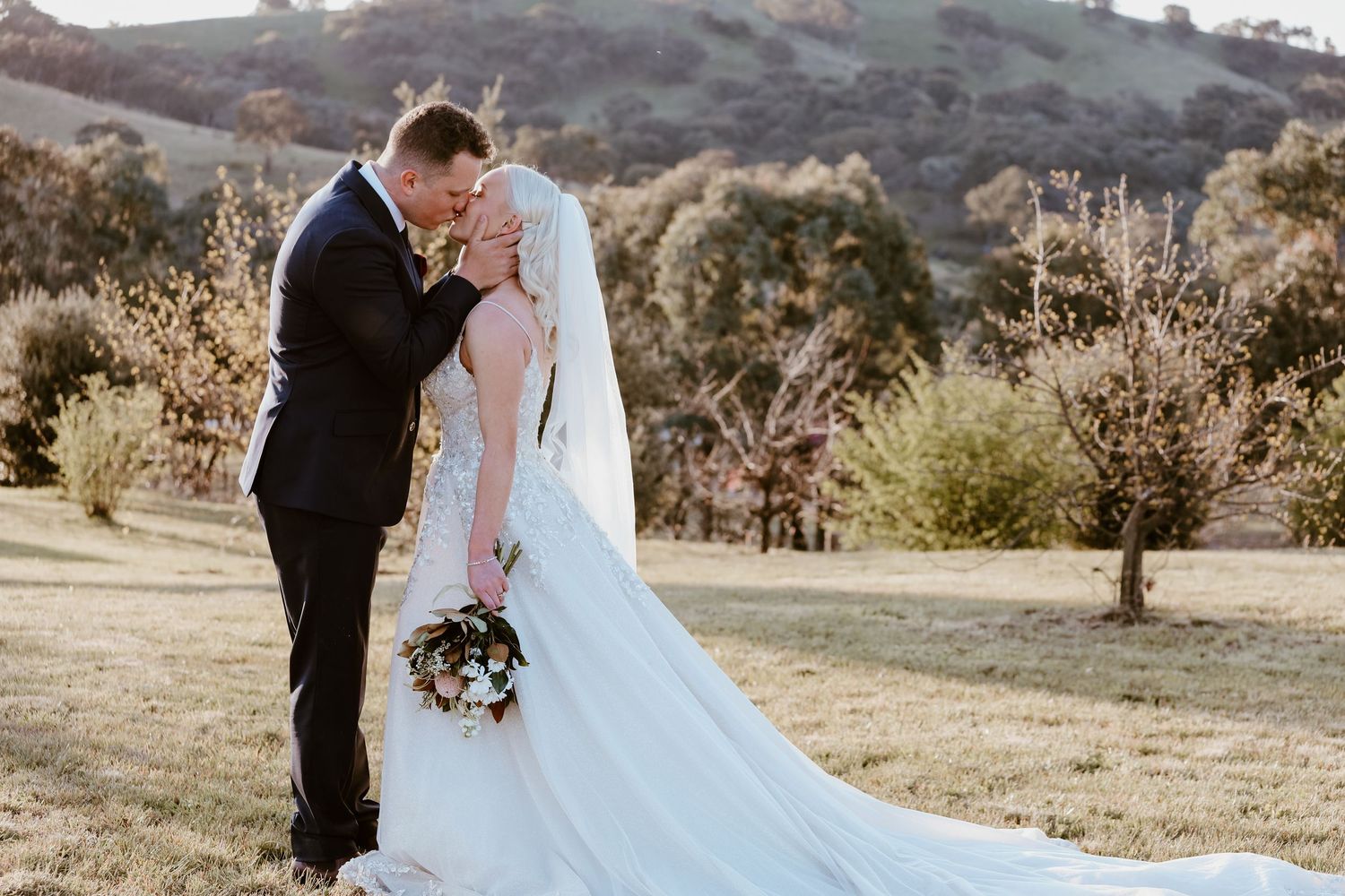 A classic wedding photography series showing tender moments between a couple at sunset in a rustic outdoor setting.