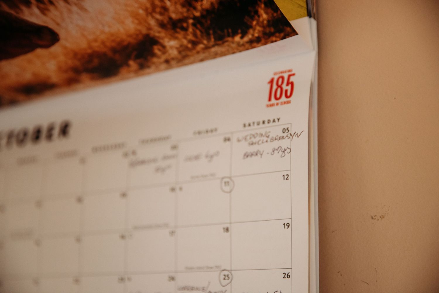 Monthly calendar displayed in warm lighting showing wedding date details.