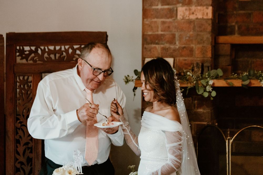 Wedding party enjoying a casual moment together at a rustic brick venue.
