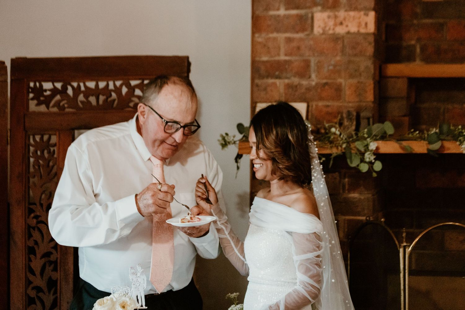 Wedding party enjoying a casual moment together at a rustic brick venue.