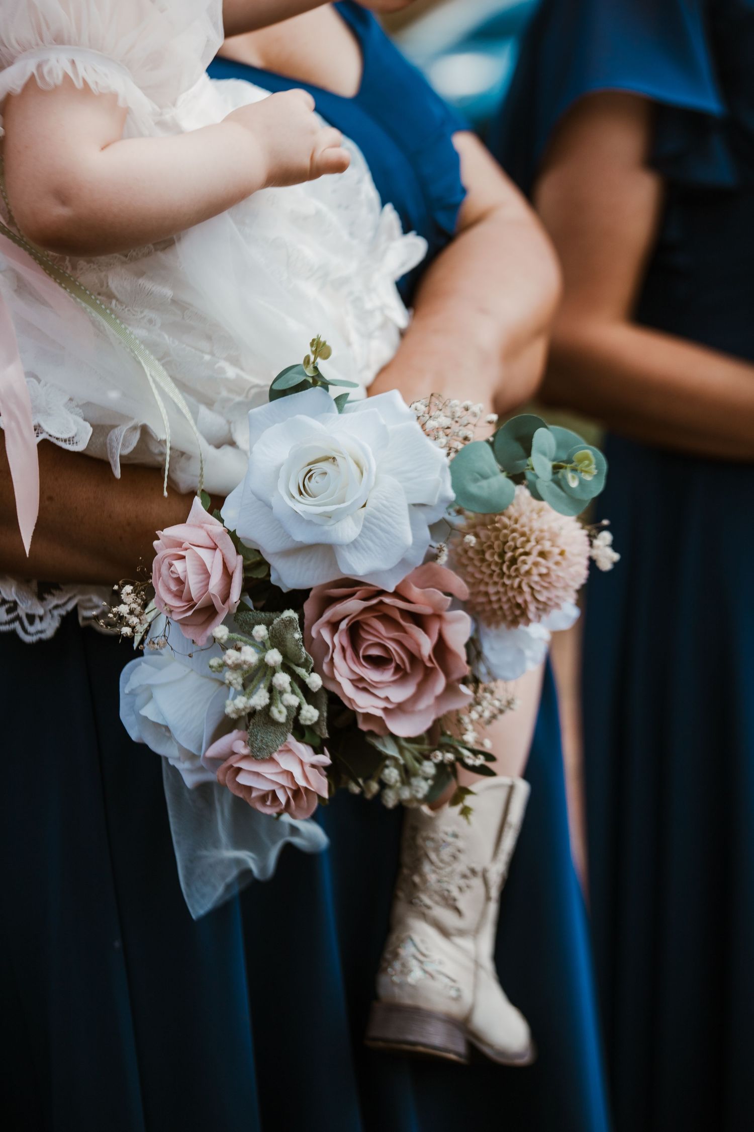 Delicate wedding bouquets featuring white and pink roses with baby's breath details.
