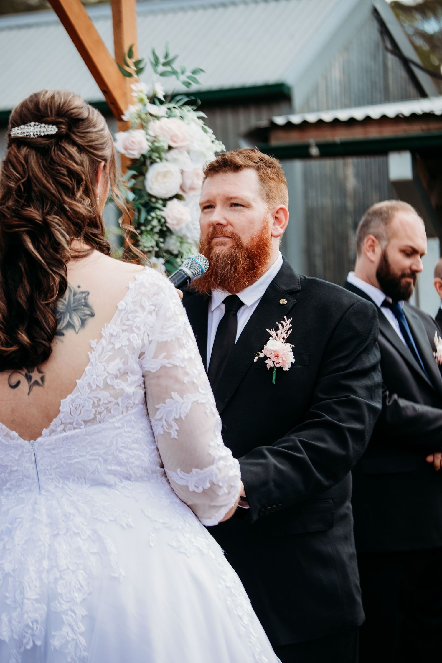 Wedding party portraits outdoors featuring white lace dress and formal black suits.