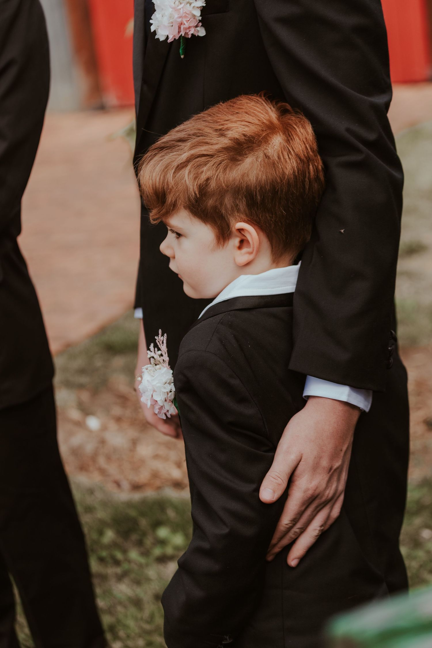 Detail shots of formal wedding attire including black suits and boutonnières.
