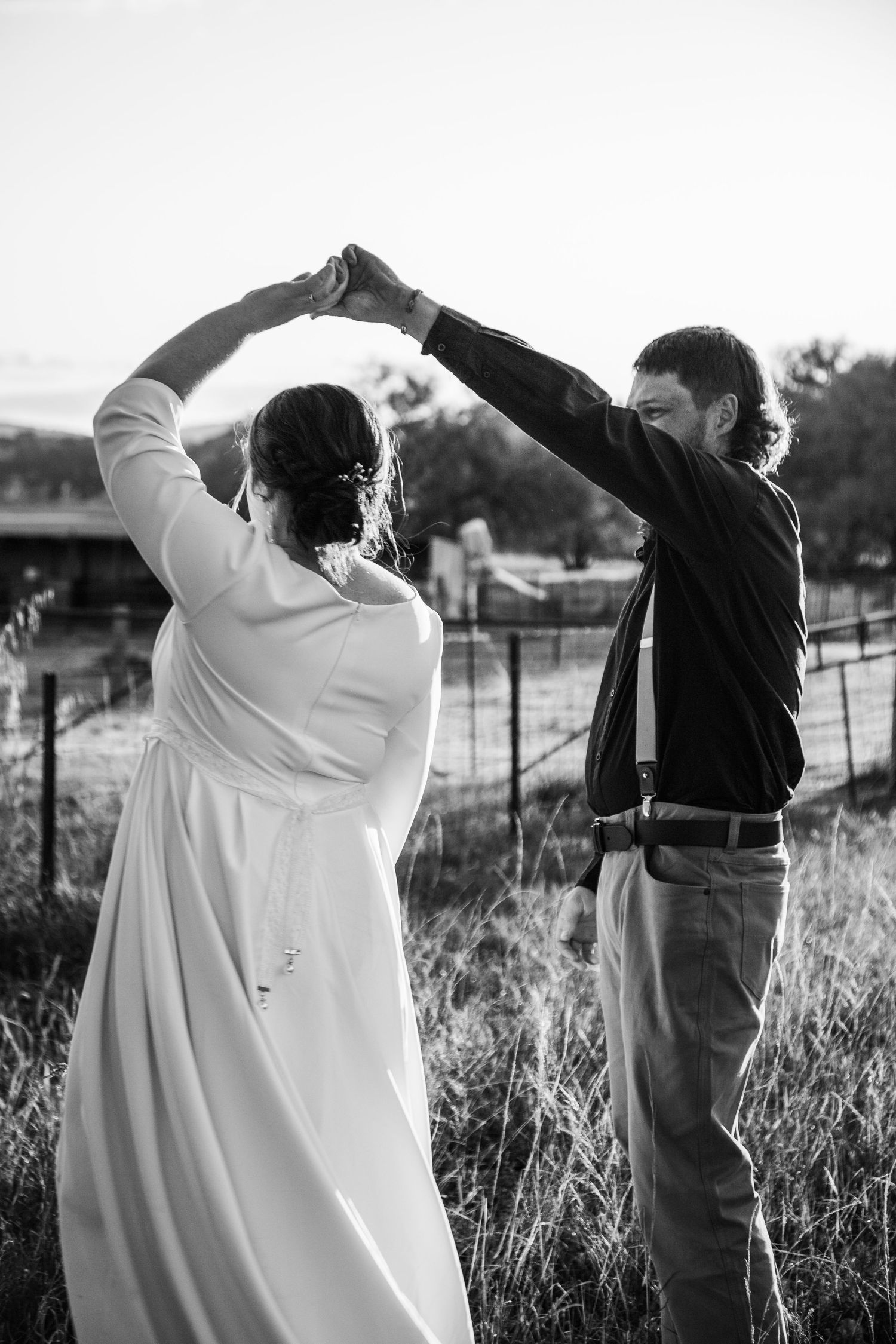 Black and white photo sequence of two people raising their arms in celebration against a rural backdrop.