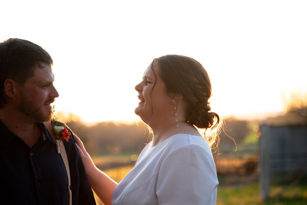 Silhouetted couple sharing a romantic moment in a golden meadow at sunset.