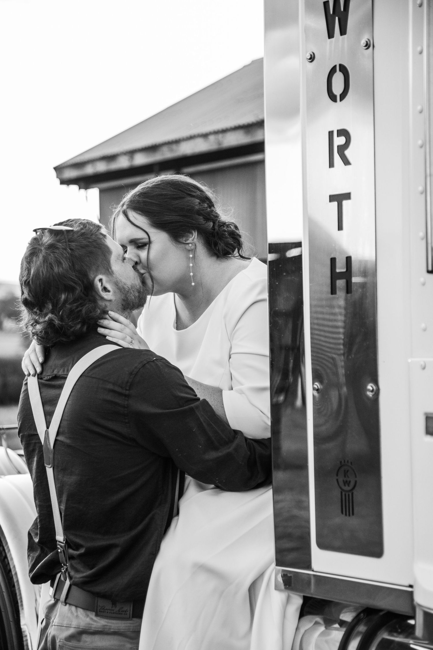 Black and white wedding portraits show intimate moments between couple against white railings.