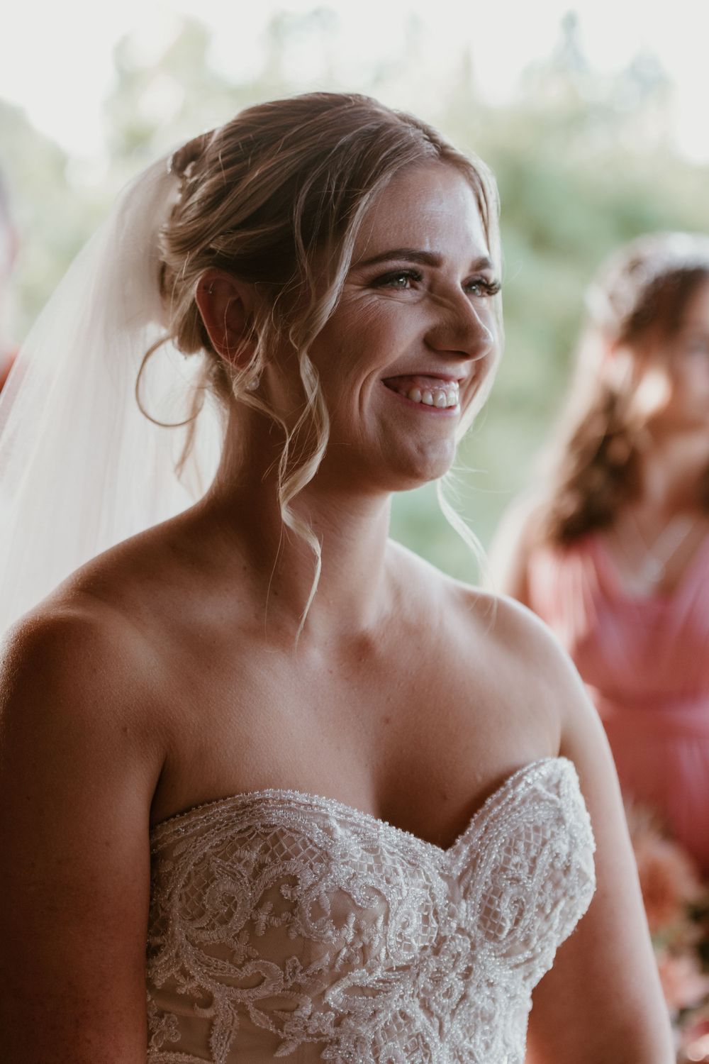 Close up portrait of bride wearing an intricately detailed strapless lace wedding gown.