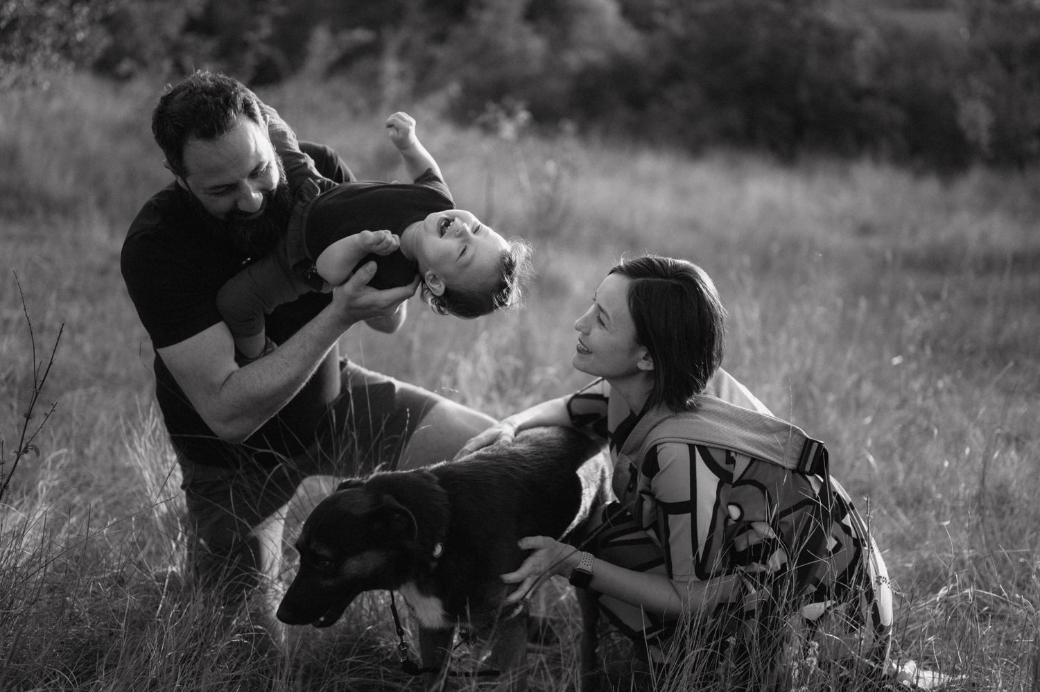 Black and white vintage sequence of two people play fighting or practicing wrestling moves outdoors on grass.